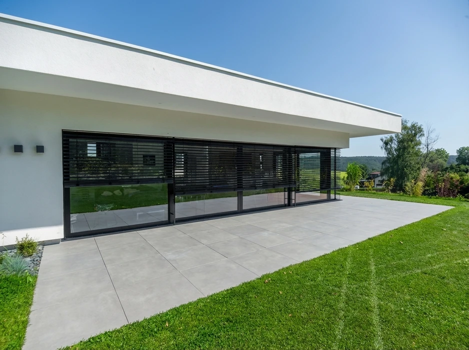 Intérieur moderne avec jardin intérieur (tsubo-niwa) enclos par des parois vitrées à châssis aluminium anthracite