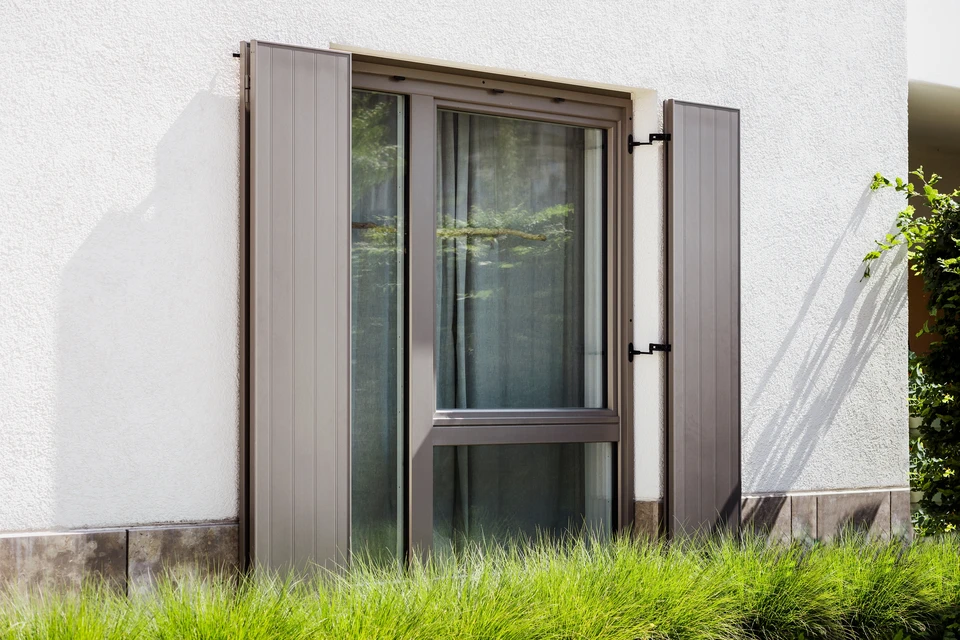 Façade moderne d'une villa avec large baie vitrée coulissante aluminium à vitrage feuilleté teinté