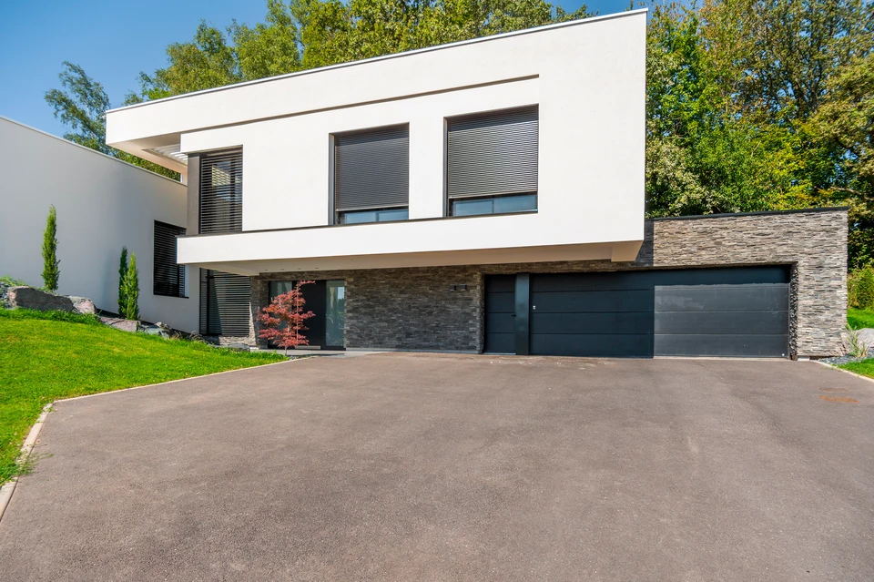Façade extérieure d'un bâtiment moderne avec volets roulants en aluminium anodisé gris anthracite, partiellement ouverts