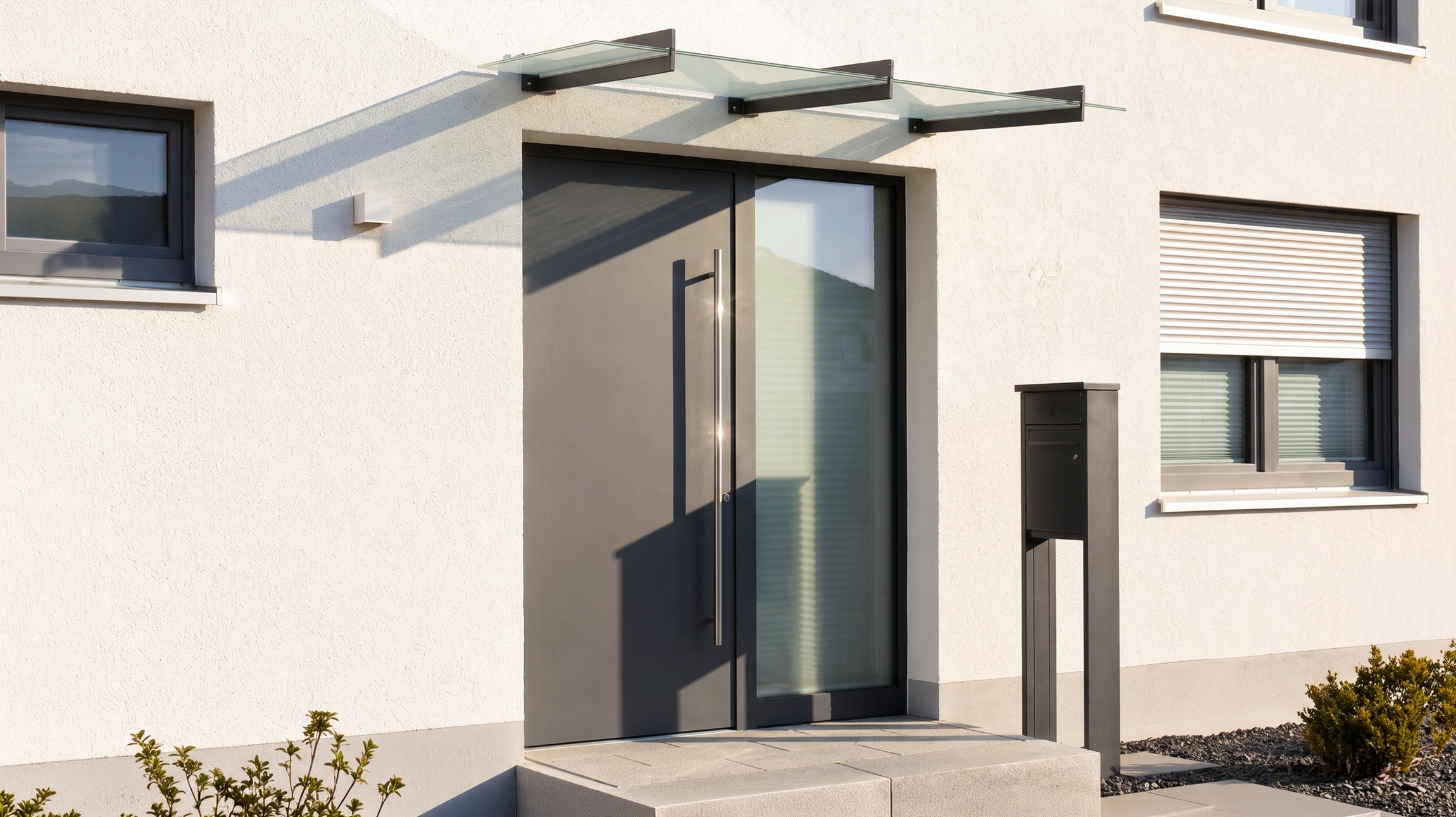 Entrée moderne d'habitation avec porte d'entrée contemporaine à panneaux vitrés et cadre anthracite